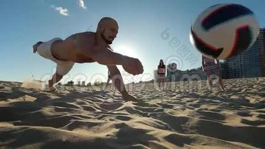 一个有运动身材的人秃头用手把球打掉，<strong>在</strong>打沙滩排球时<strong>摔倒在地</strong>
